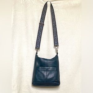 The Sak dark teal cross body leather purse with nylon strap.